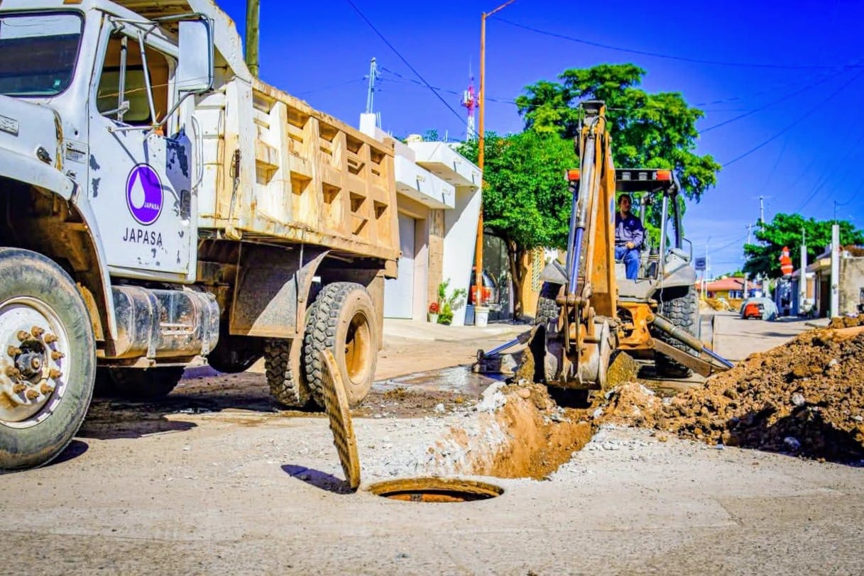Máquina de construcción, drenaje abierto y montones de tierra alrededor
