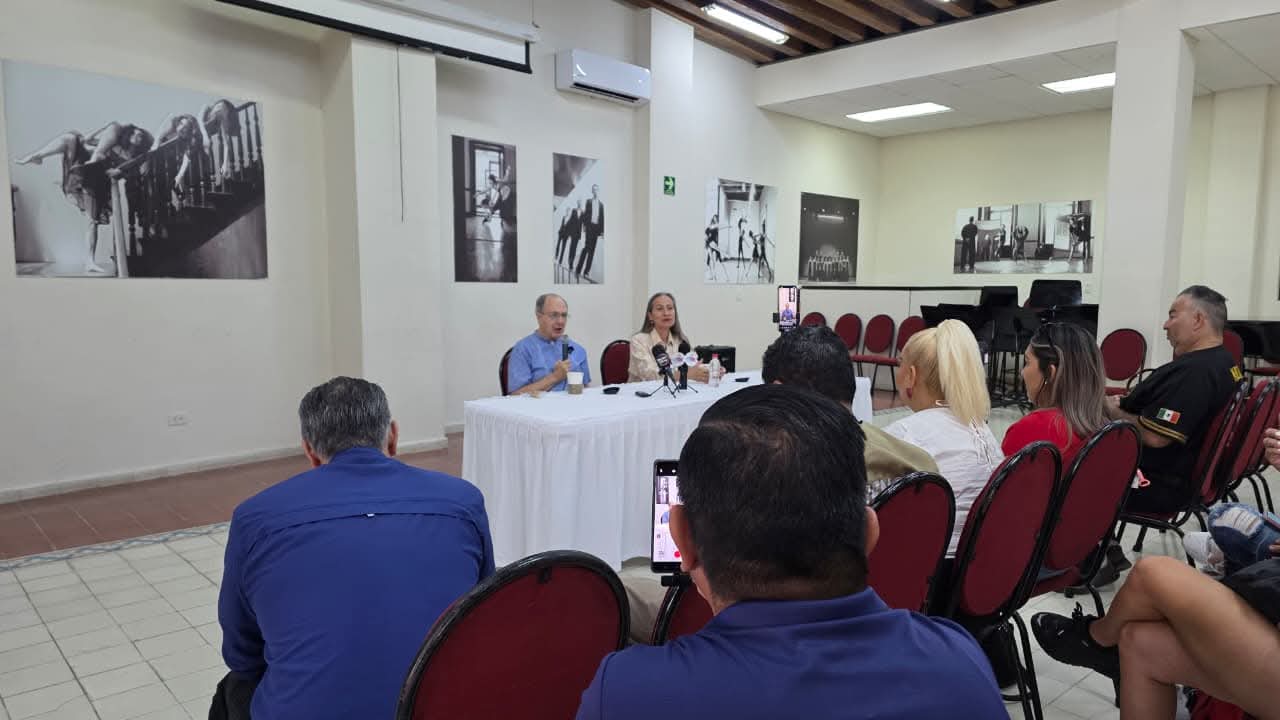 personas sentadas detrás de mesa en rueda de prensa