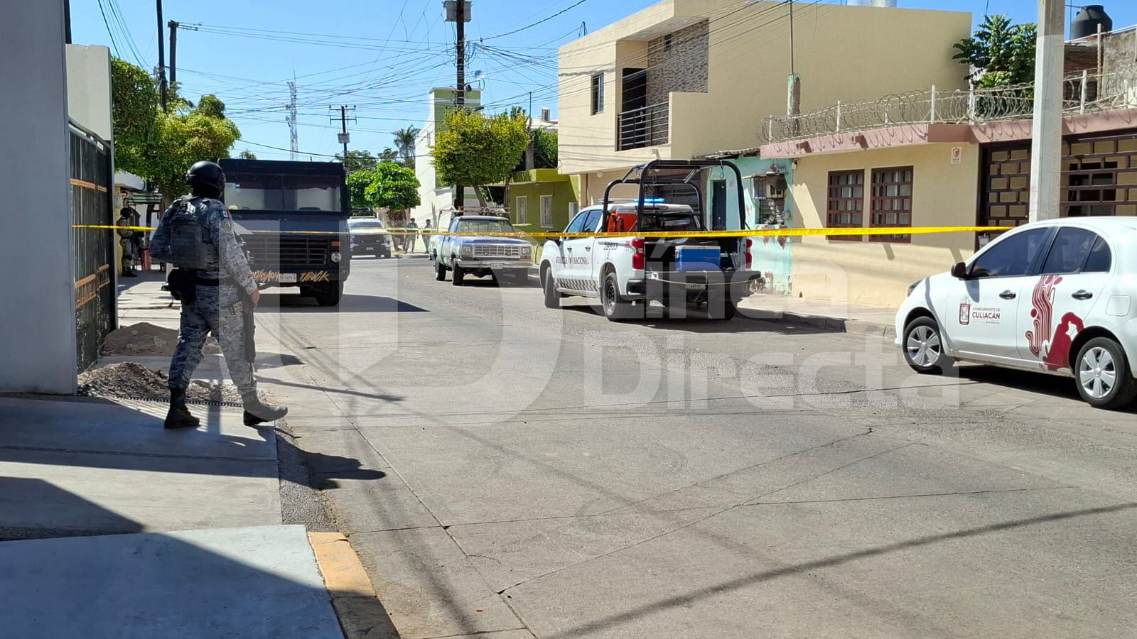 Patrulla de la Guardia Nacional en una calle con una cinta amarilla de precaución y elementos desplegados por la zona entre carros particulares estacionados