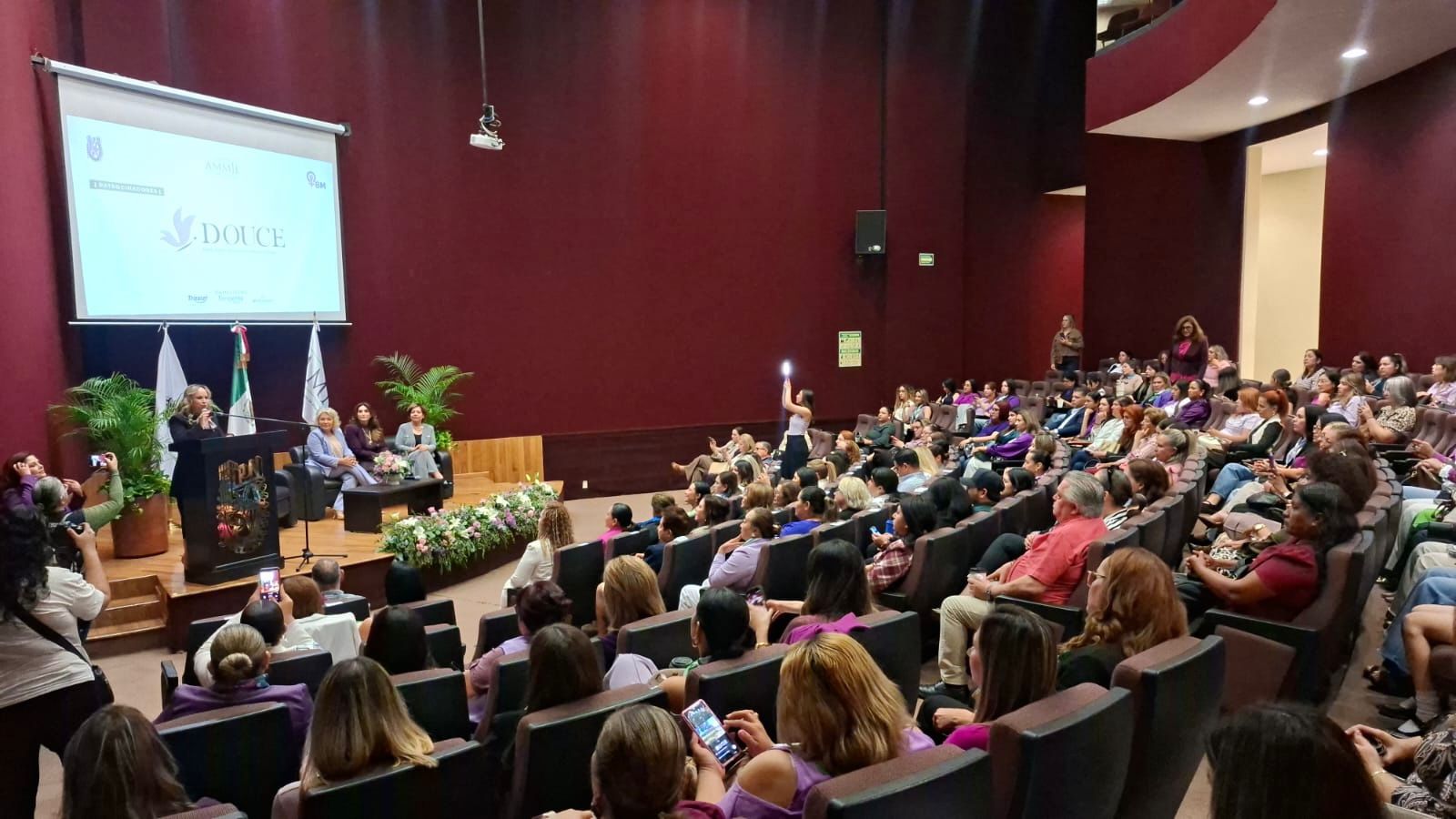 Lugar de reunión con personas alrededor frente a pantalla grande