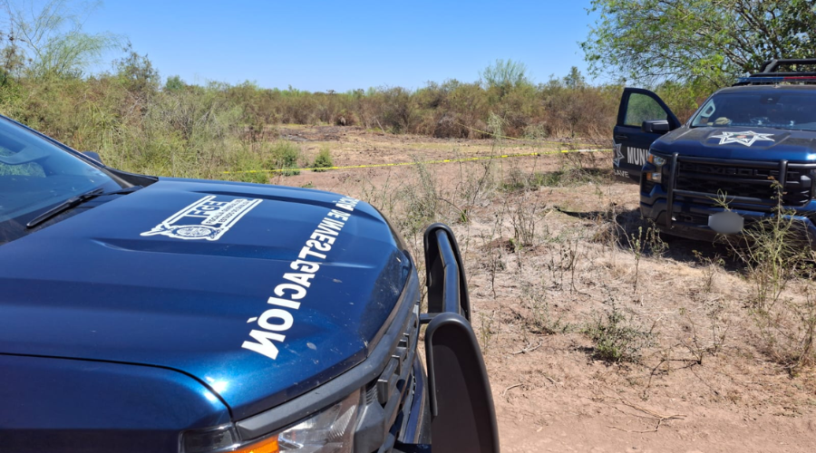 Unidades de seguridad y de la FGE estacionadas en un terreno baldío y una cinta amarilla acordonando la zona