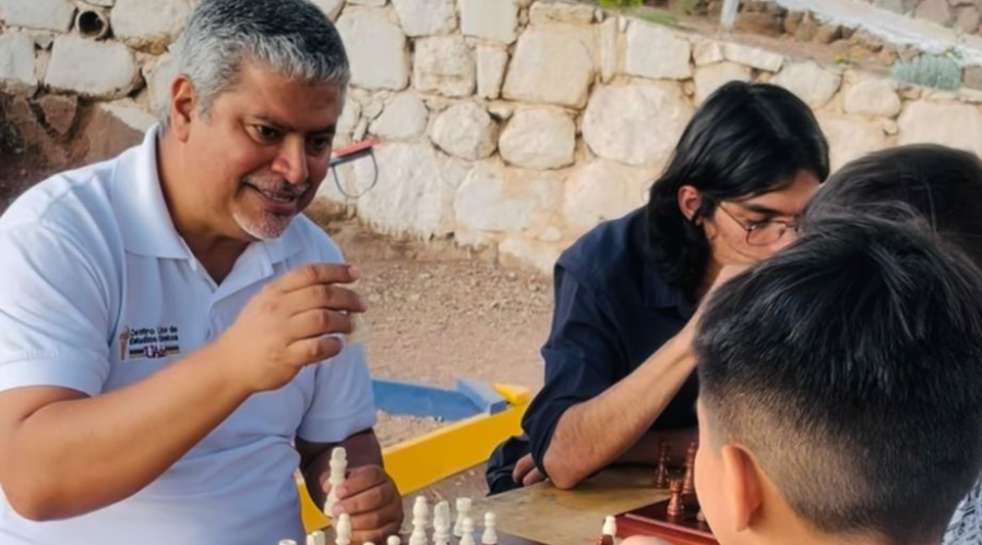 Hussein Muñoz, profesor sinaloense junto con unos niños jugando ajedrez