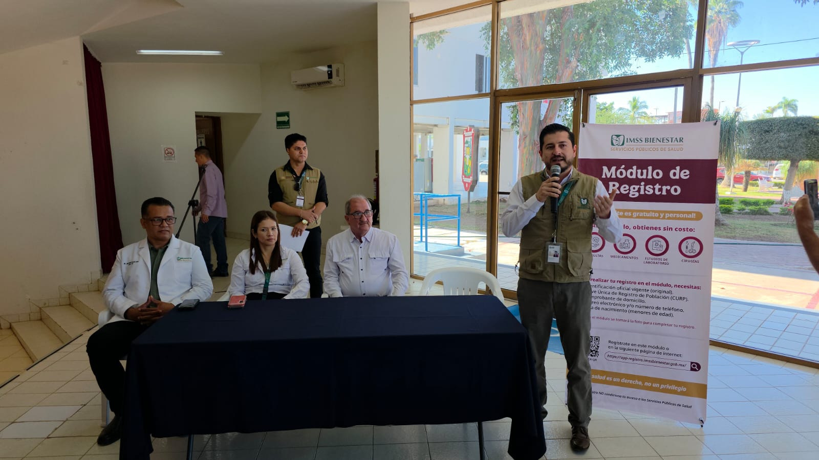 Personal de IMSS sentados detrás de mesa