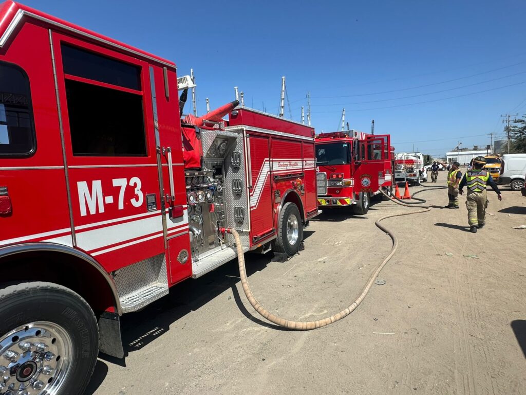 Camión de bomberos junto a dos bomberos en Mazatlán