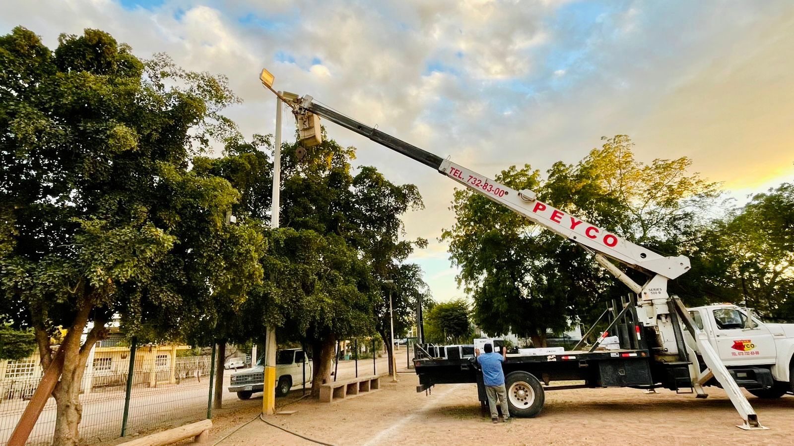Camión de luz instalando postes