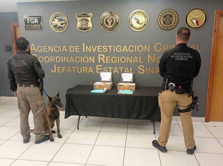 De espaldas autoridades de seguridad y en la mesa drogas interceptadas