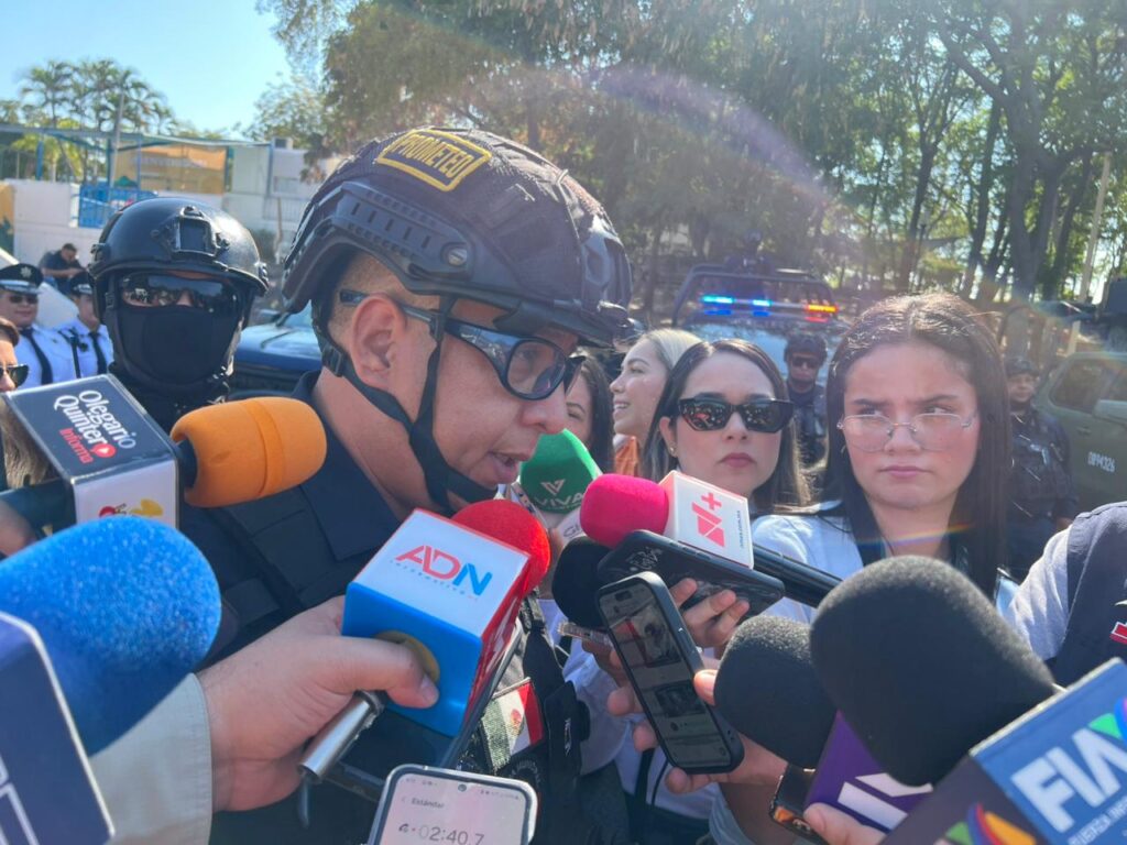 Persona con casco y lentes hablando a muchos micrófonos