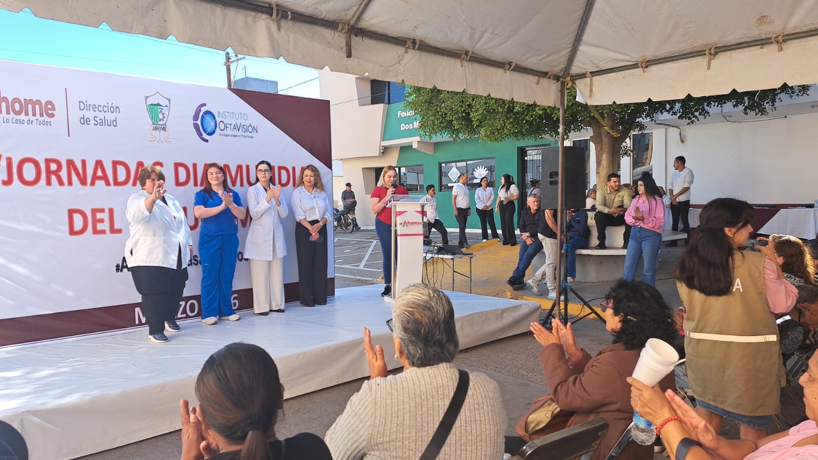 Personas en un templete afuera de Salud Municipal de Ahome