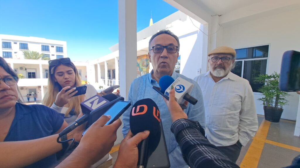 hombre con micrófonos y celulares frente a él