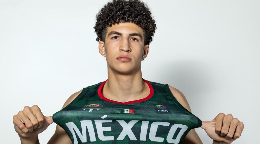 Jugador posando para la foto jalando su camiseta enseñando las letras de México