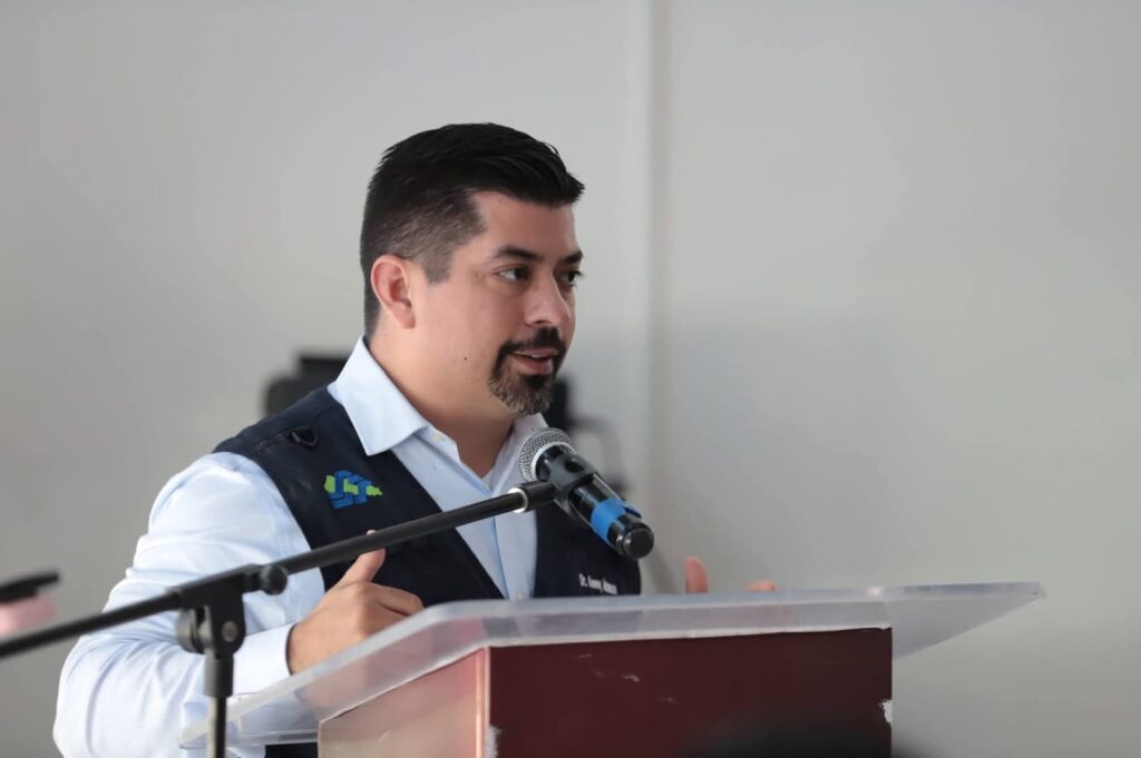 Persona (Kenny Inzunza Leyva) hablando en un pulpito con un micrófono