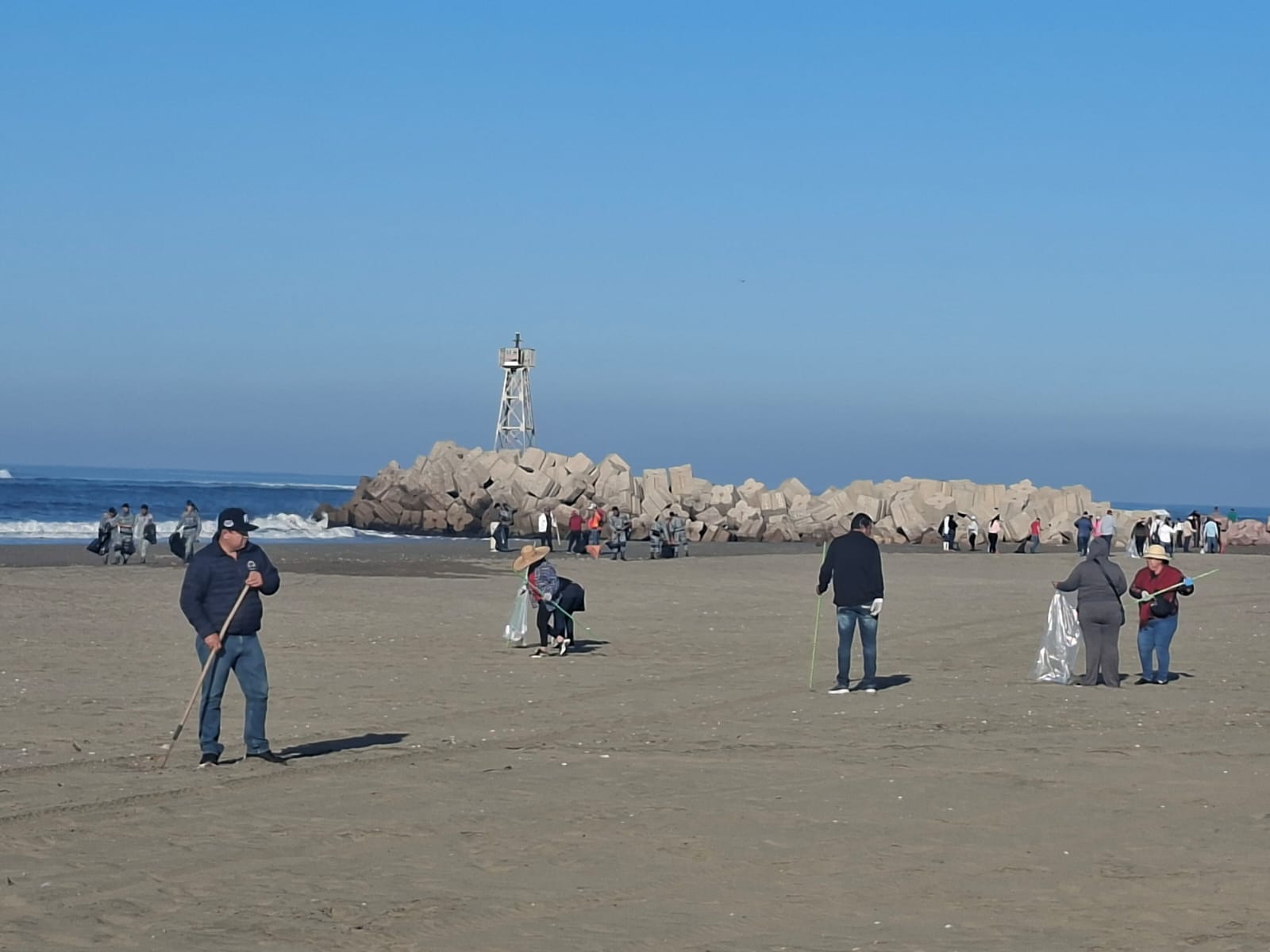 grupo de personas limpiando playa