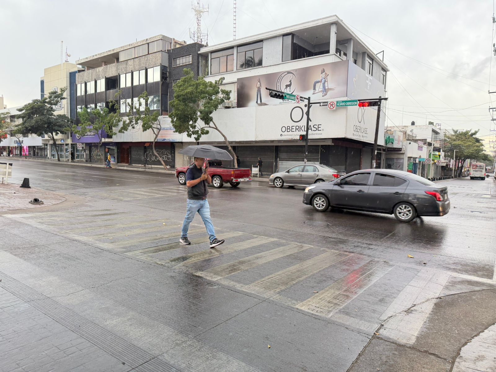 Calle mojada con una persona con un paraguas