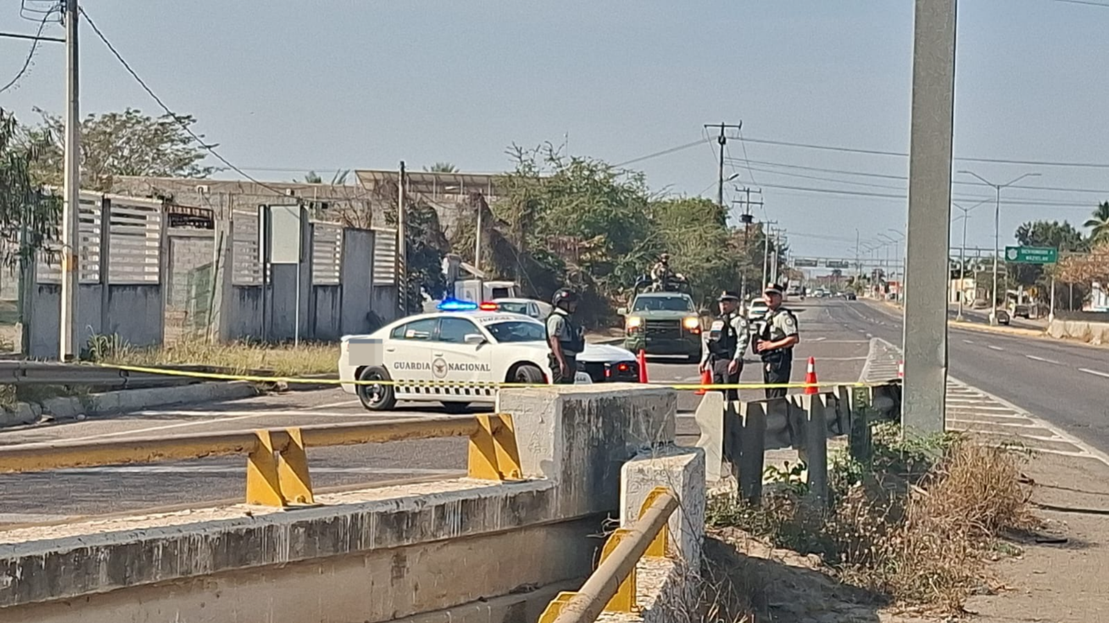 Elementos de la guardia nacional y ejercito mexicano en medio de la carretera asegurando zona