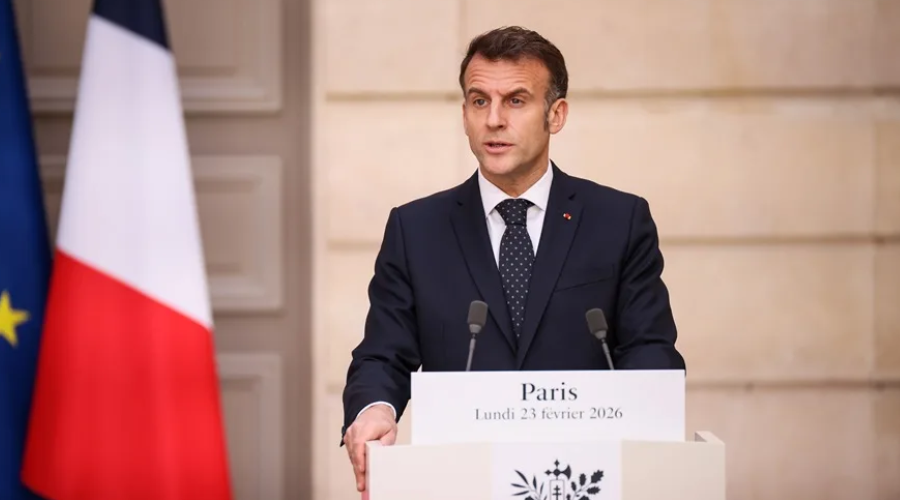 El presidente de Francia, Emmanuel Macron hablando desde un podio junto con la bandera de Francia