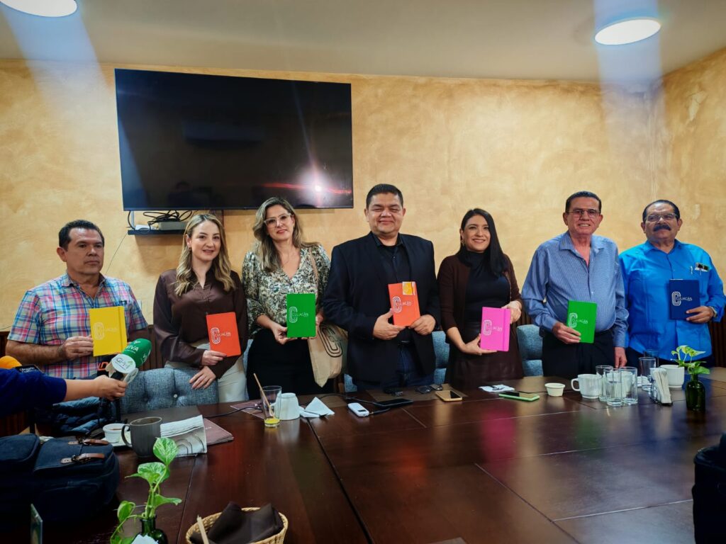 Empresarios en conferencia de prensa con libreta en su mano con el logo de Empresarios invitan a la sociedad a integrar marca Ciudad Culiacán, México