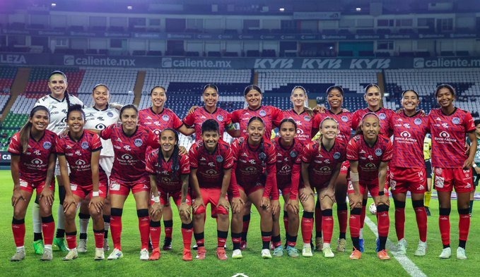 Jugadoras de futbol posando para foto en estadio