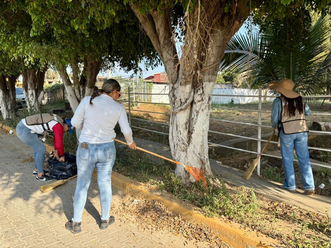 Mujeres realizando limpieza de vialidad