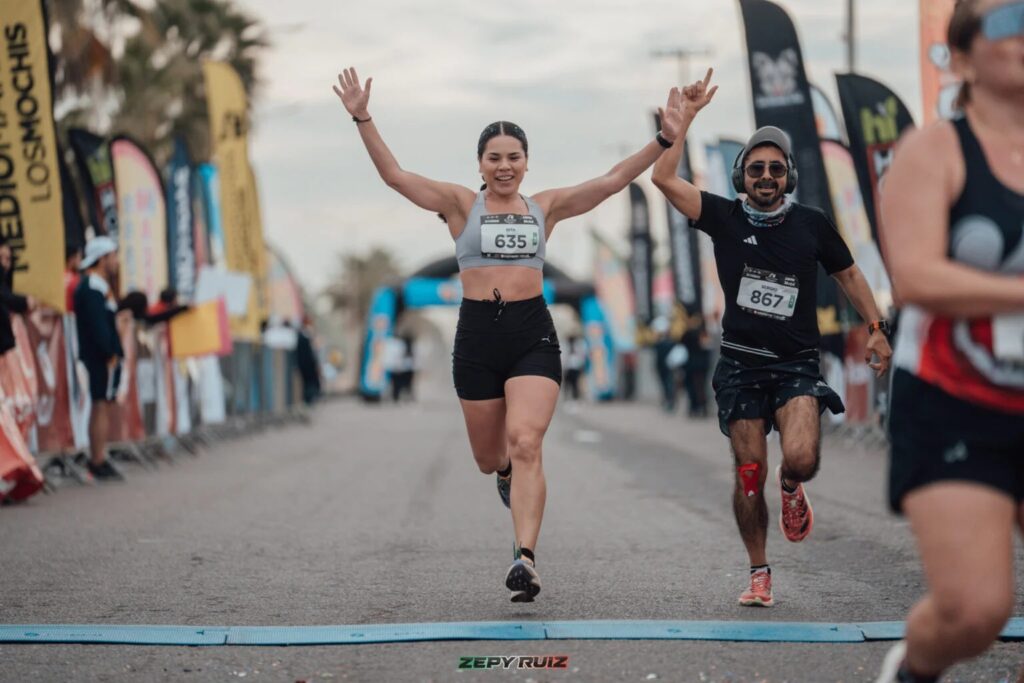 Una mujer cruzando la meta del medio maratón