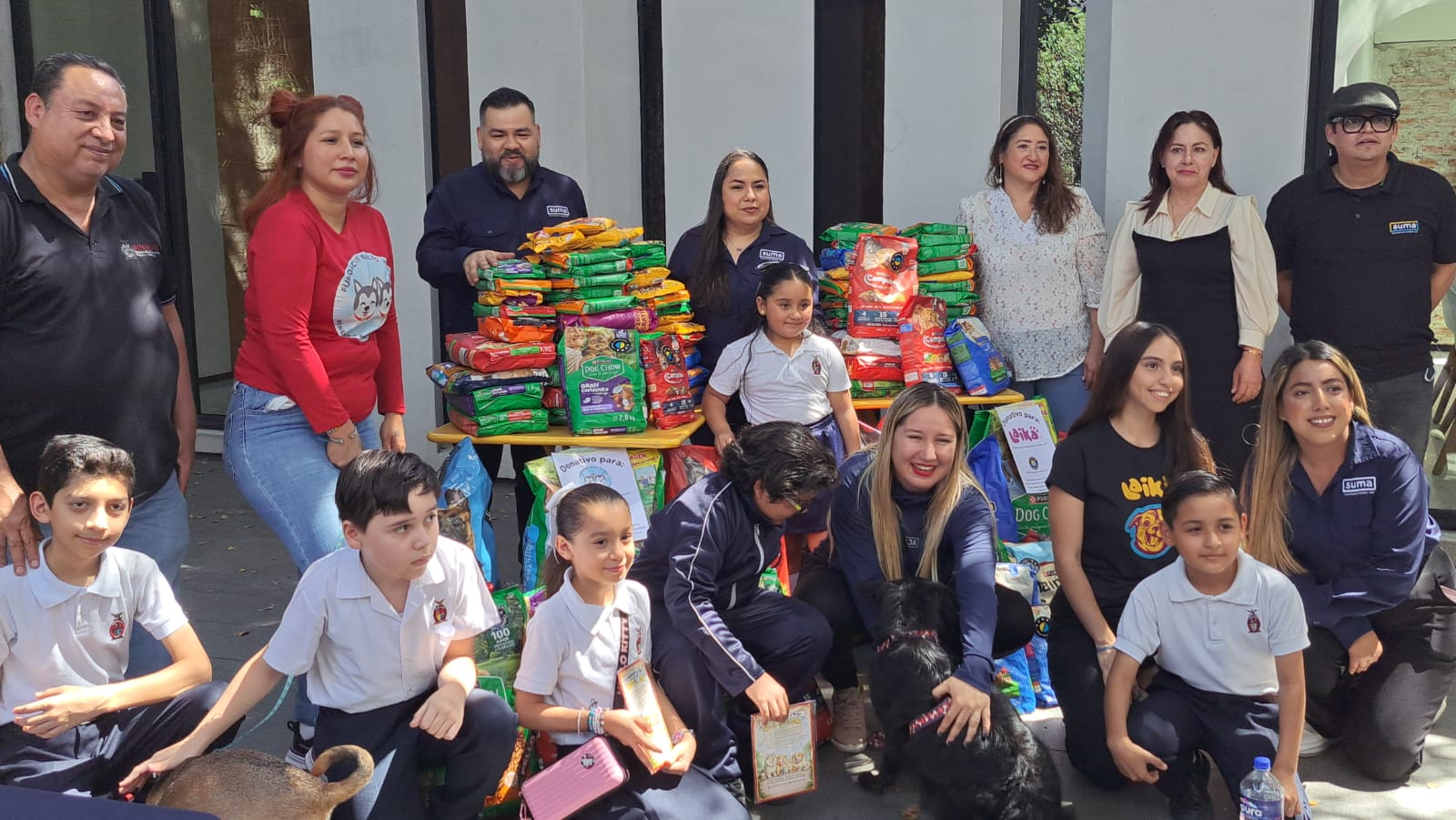 Autoridades e infantes junto a donativo de comida para animales