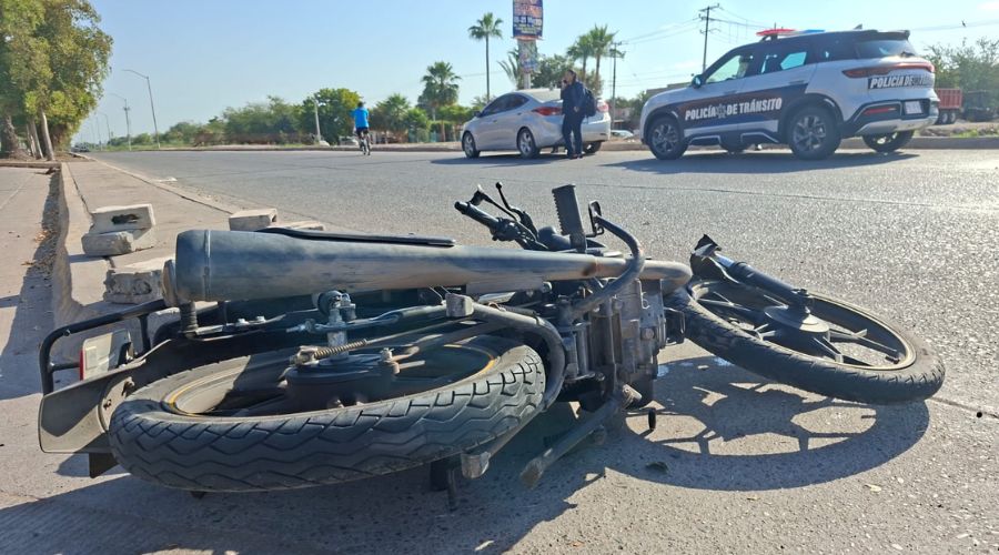 Motocicleta en el suelo y detrás unidad de transito estacionado