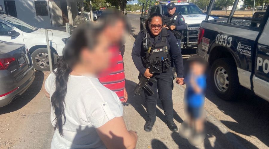 Elementos de policía junto a niño rescatado y familiares que tienen la cara blureada