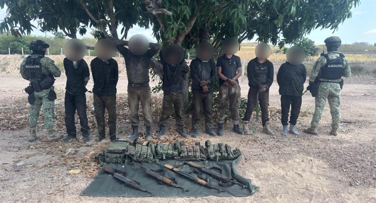 Personas con los rostros blureados parados debajo de un árbol y a los costados elementos de seguridad