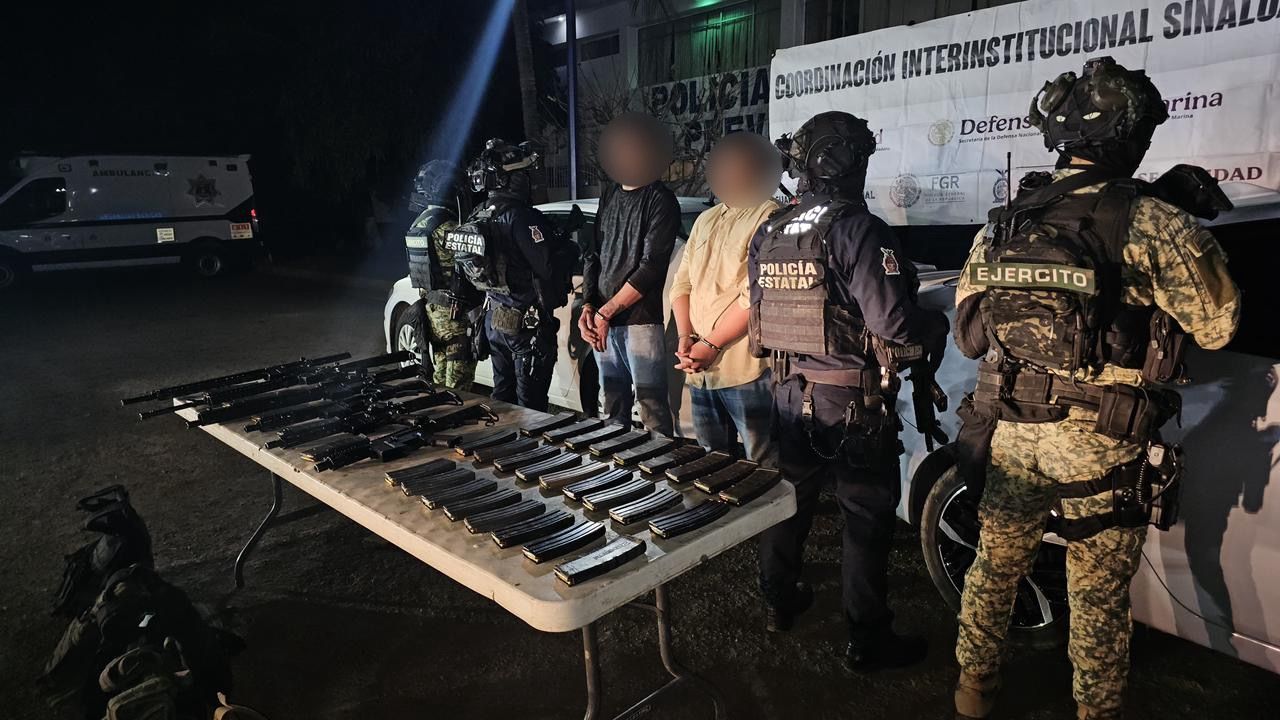 Personas detenidas y elementos del ejercito detenidos, sobre una mesa armas y cartuchos confiscados