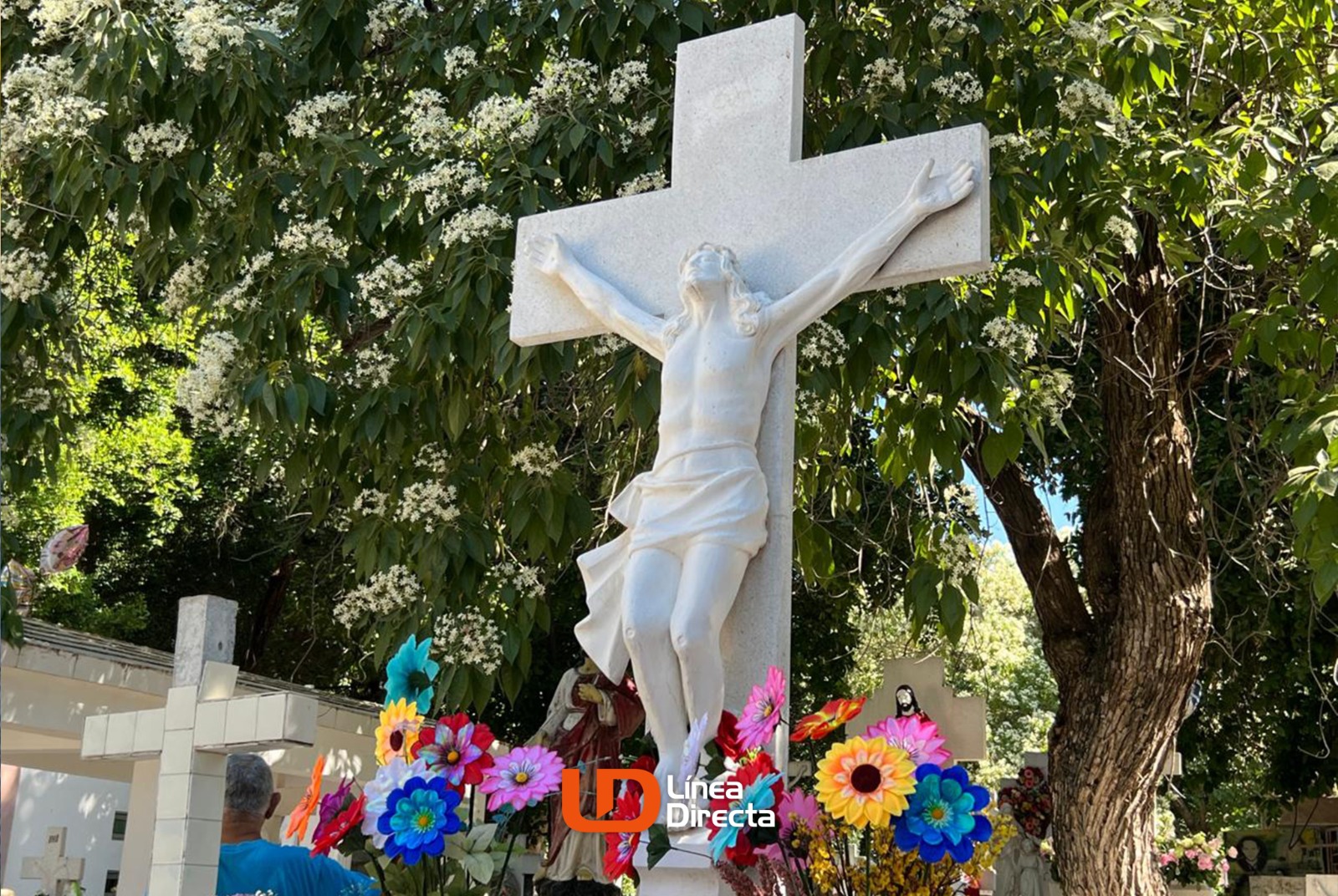 cruz de tumba en panteón con flores