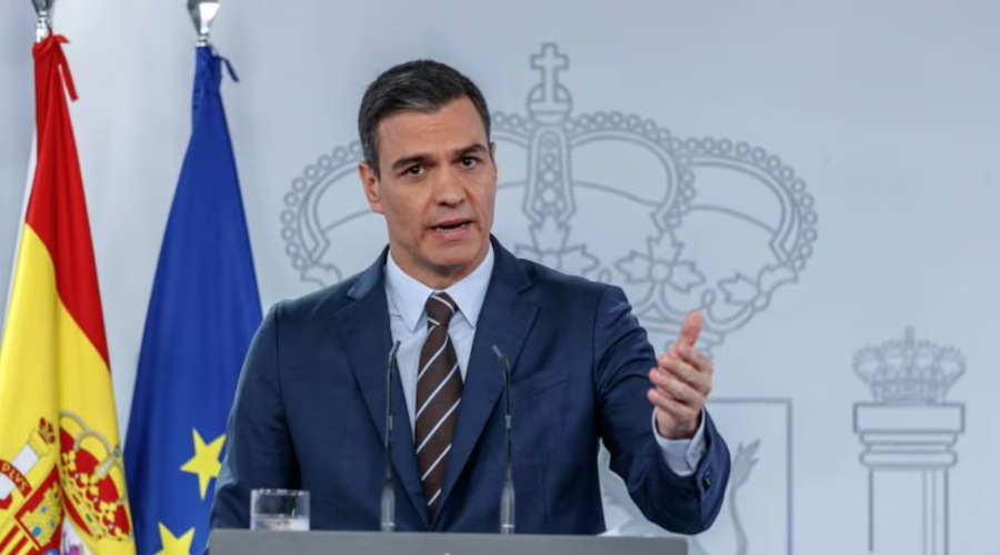 Pedro Sánchez, presidente del Gobierno de España en un podio junto con la bandera de españa