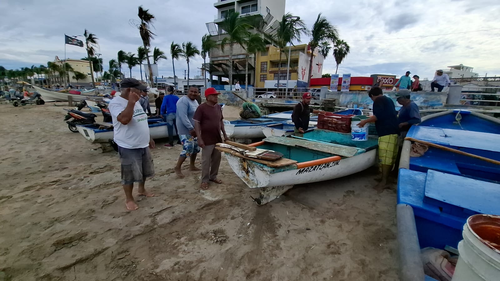 Pescadores junto a pangas en la orilla del mar