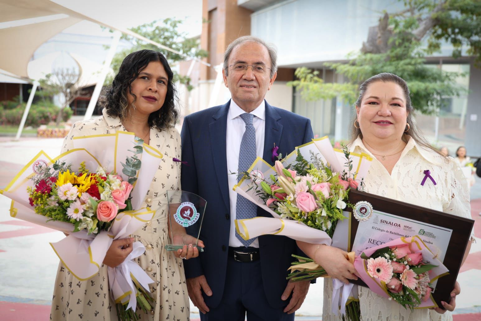 Mujeres con flores y premios en mano