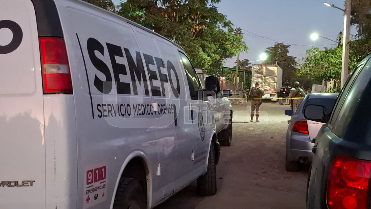 Unidad del Semefo en una calle de terracería con una cinta amarilla de precaución y al fondo se observan elementos policiacos