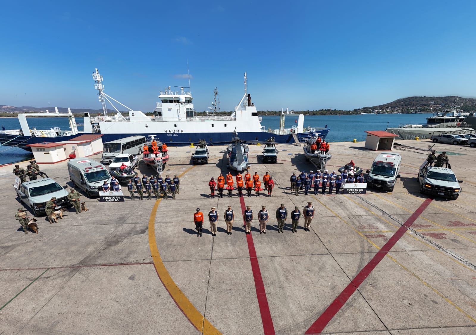 Formación de elemtos de la Marina junto a un barco