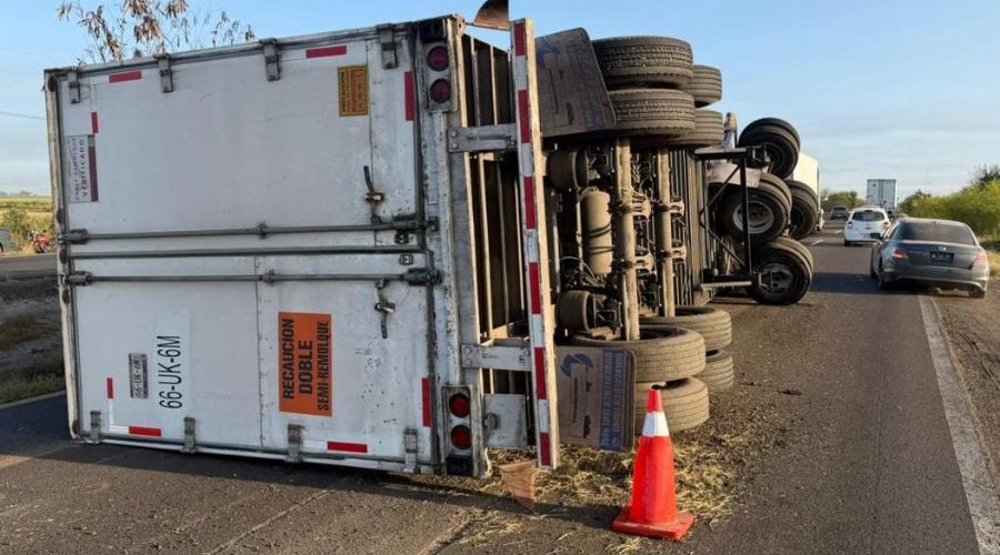 Táiler volcado en una carretera y un cono naranja