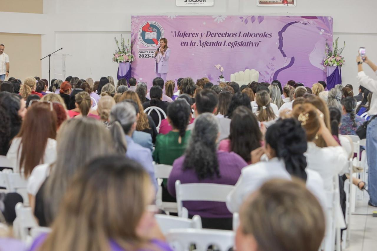 Tere Guerra durante una conferencia y frente a ella mujeres