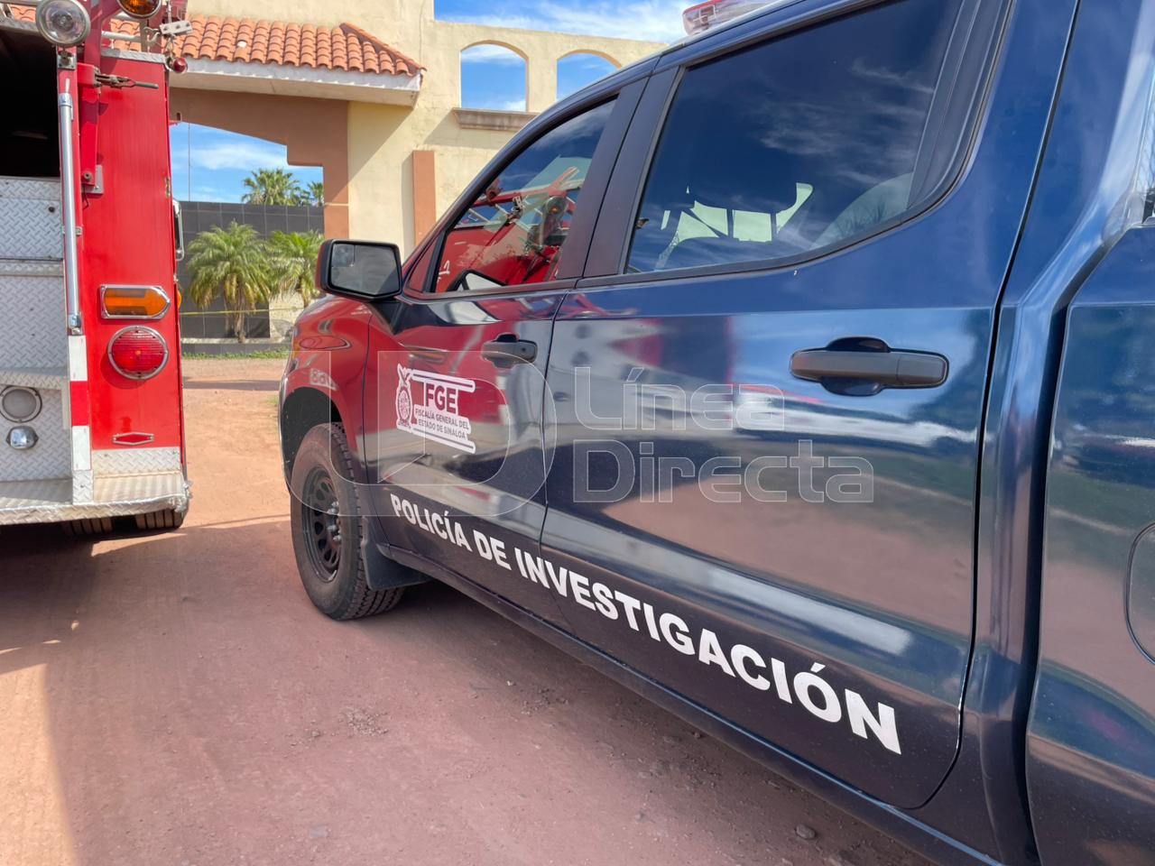 Unidad de la FGE y camión de bomberos estacionados a las afueras de un motel