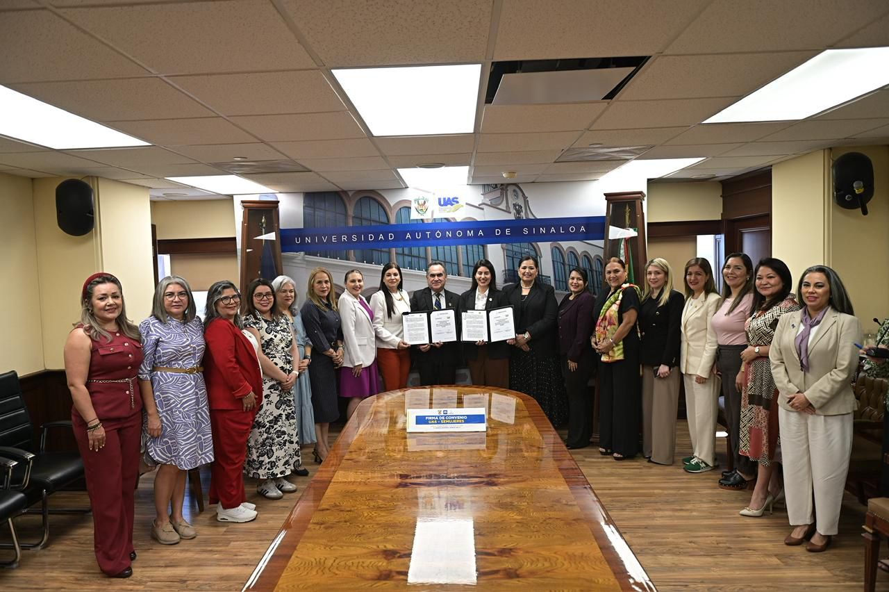 Mujeres funcionarias sonriendo a la cámara con documento en mano