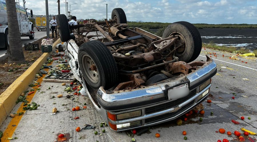Camioneta volcada en carretera y alrededor mercancía de verduras regada por el suelo