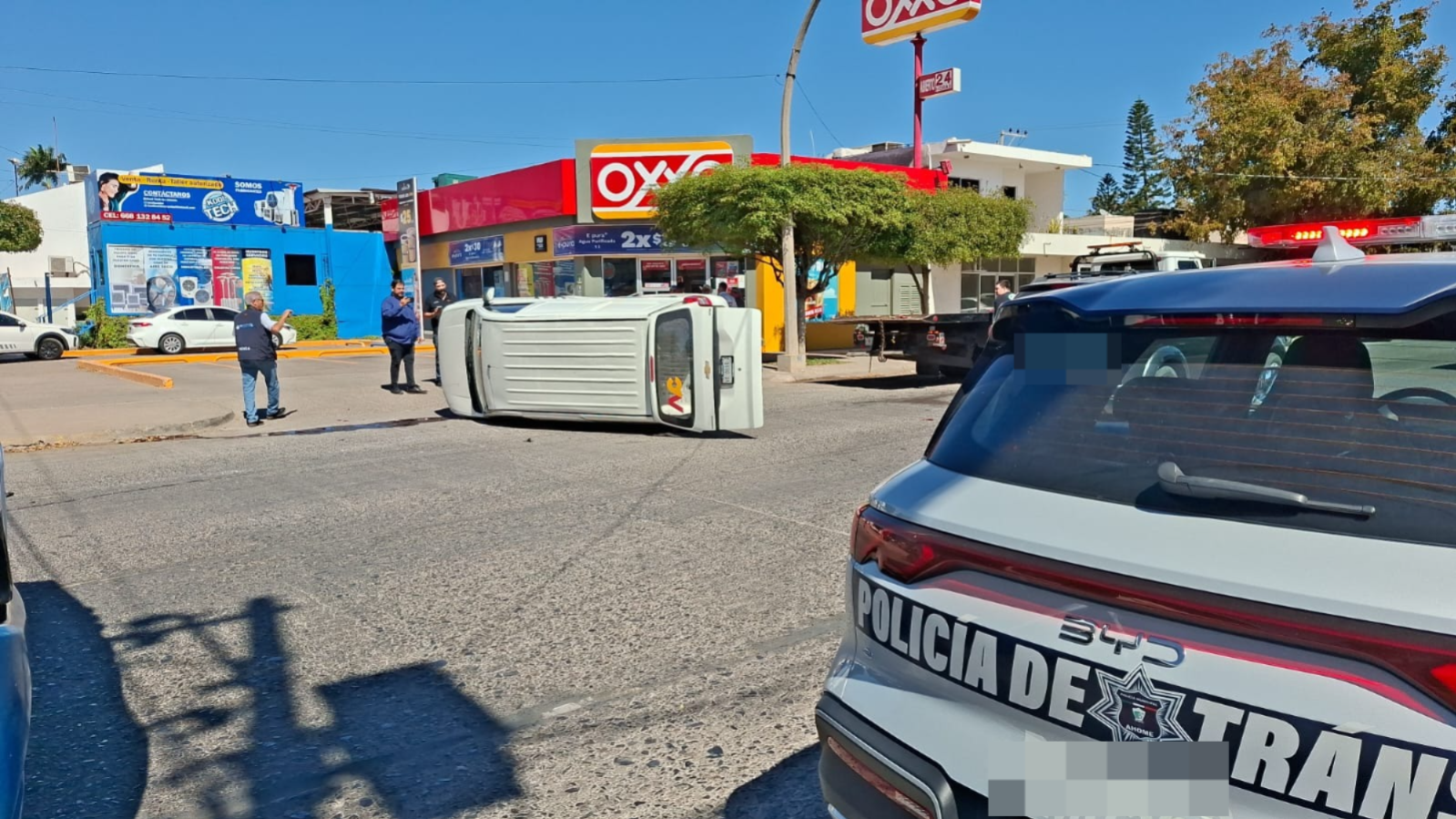 Auto blanco volcado en vialidad, unidad de transito en la zona
