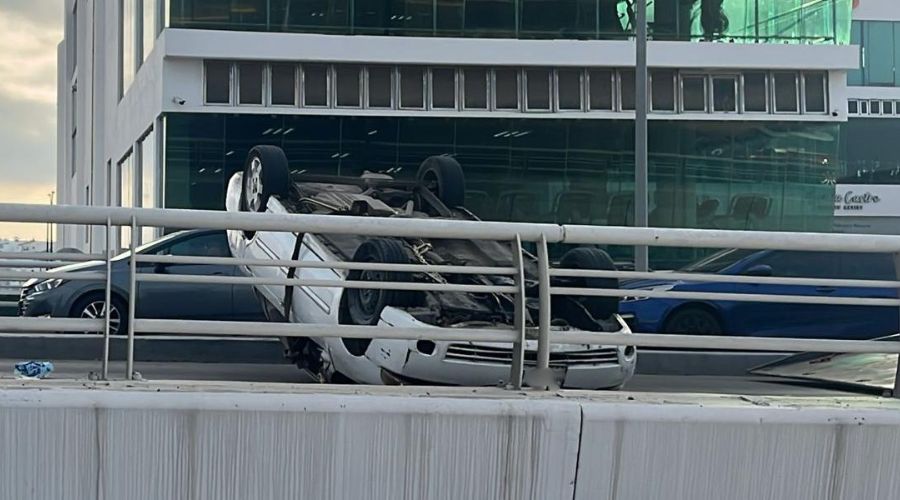 Carro blanco volcado sobre una calle