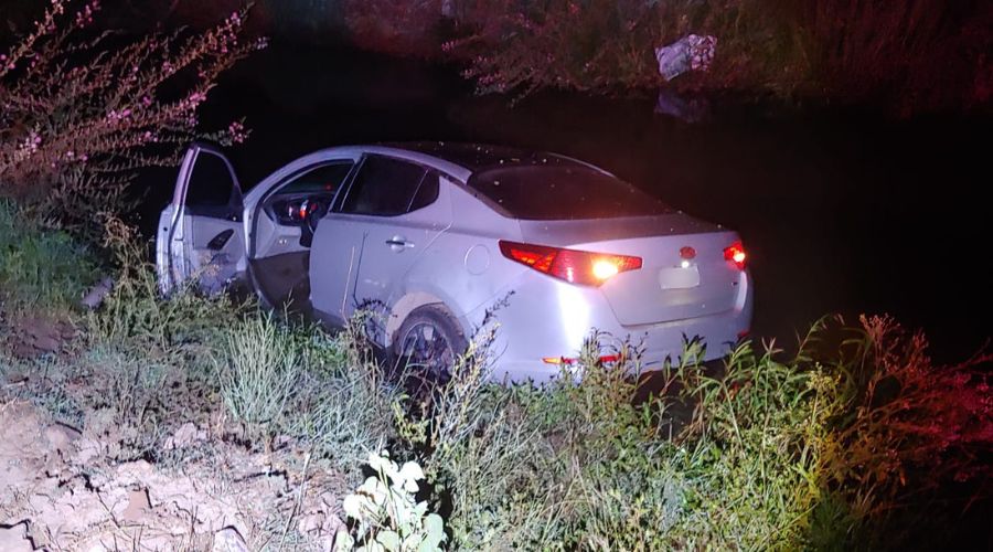 carro de color gris con golpes adentro de un canal
