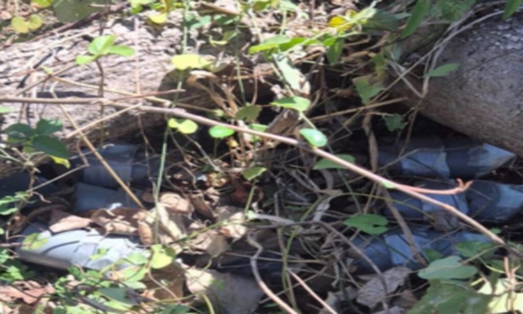 artefactos envueltos en cinta gris y tirados en el suelo entre ramas y palos