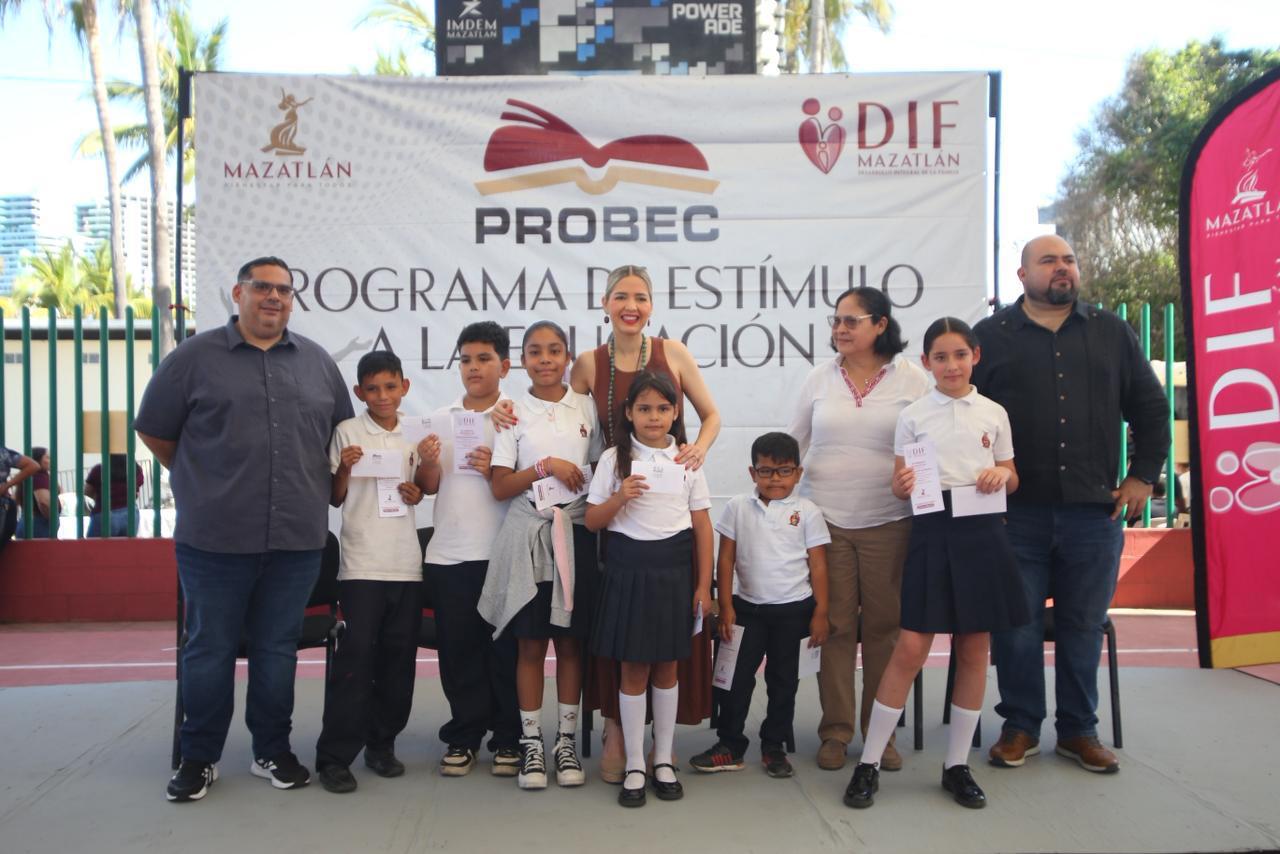 Adultos y niños en una escuela durante un evento de entrega de pagos de beca
