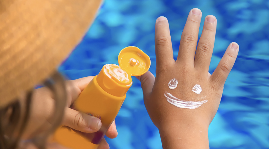 Mano de un niño con bloqueador solar