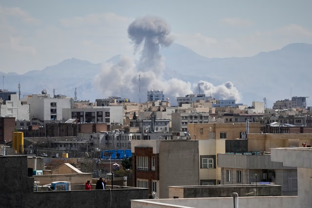 nube de humo por explosión por guerra detrás de casas