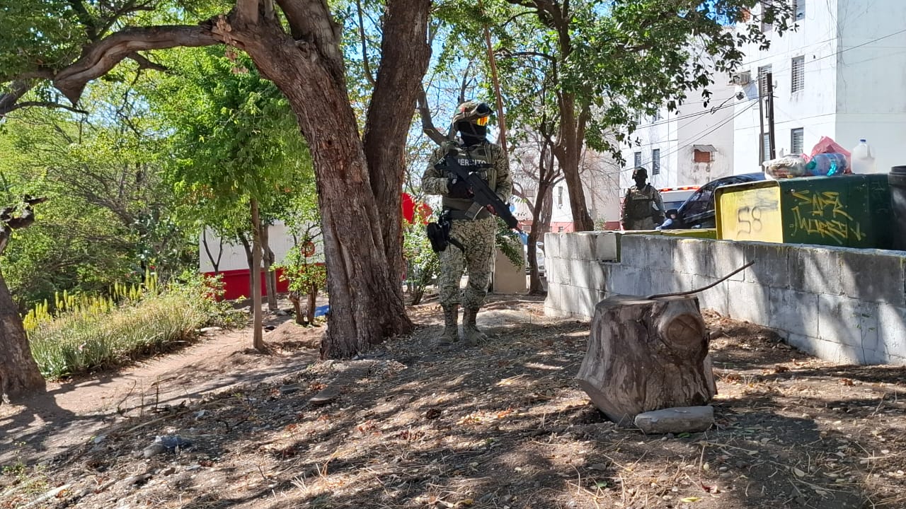 Militar frente a departamentos donde se enncuentra un cuerpo tendido