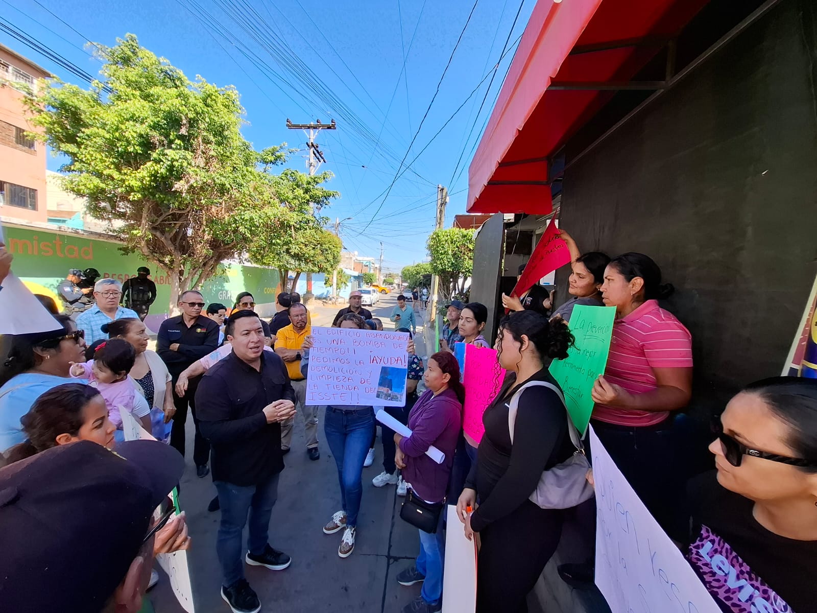 Personas con cartulinas afuera de una escuela