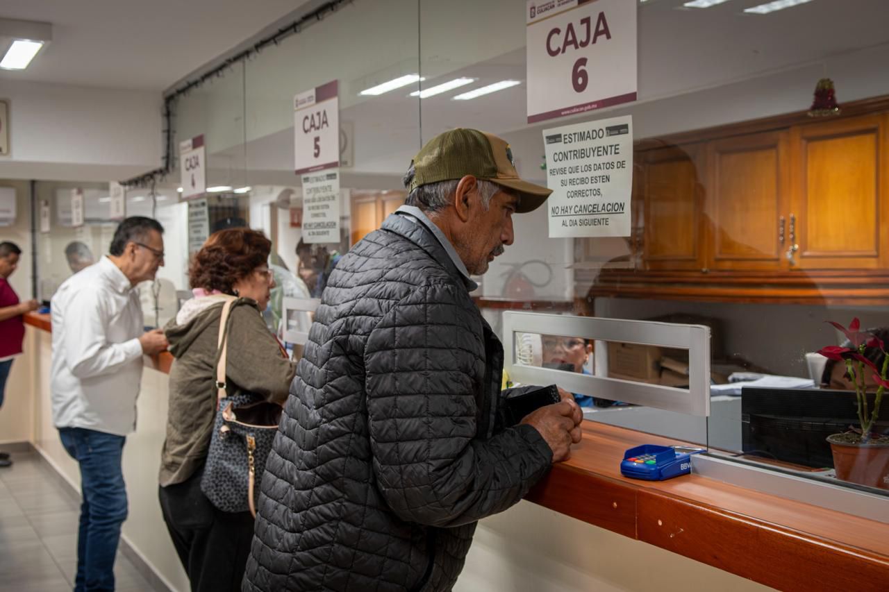 personas pagando en ventanilla de pago