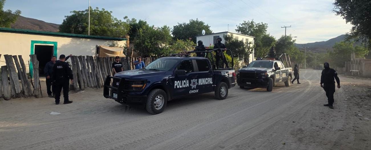 patrulla municipal y elementos policiacos junto a civiles afuera de una casa sobre un camino de terracería